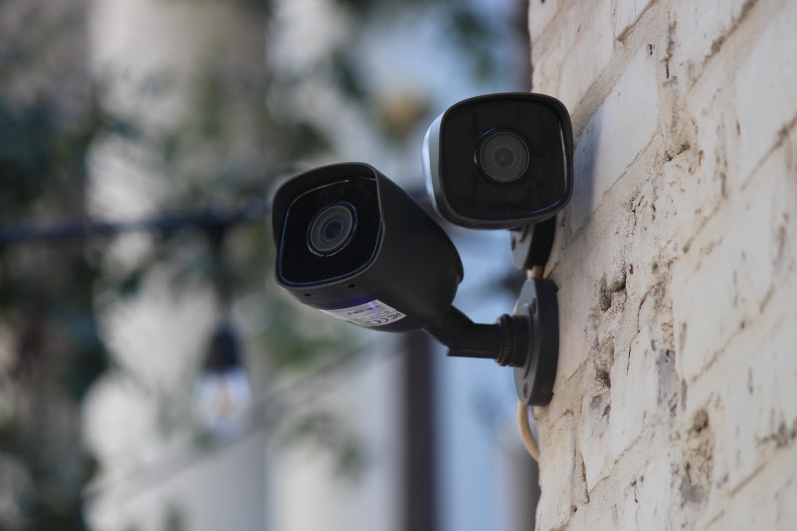 Two cameras on a brick wall